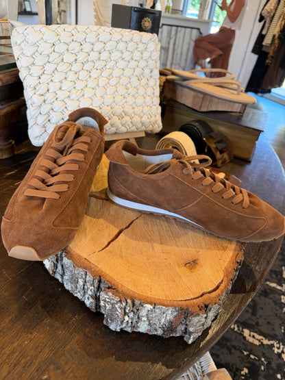 Brown sneakers against a wooden background