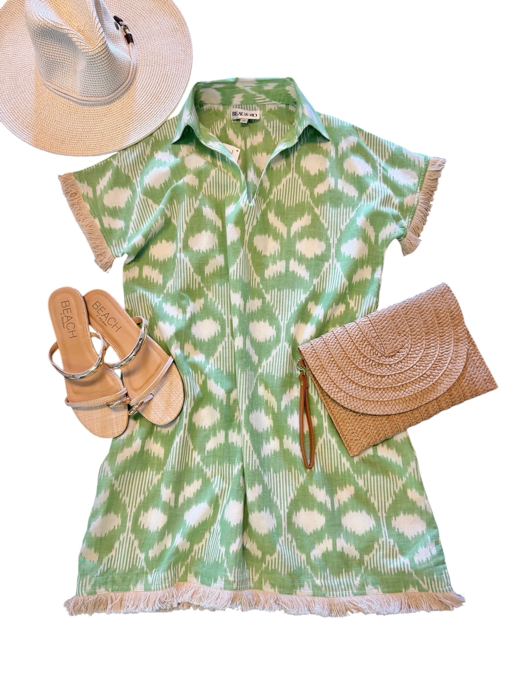 Flatlay of women's beach dress styled with sandals and straw accessories 