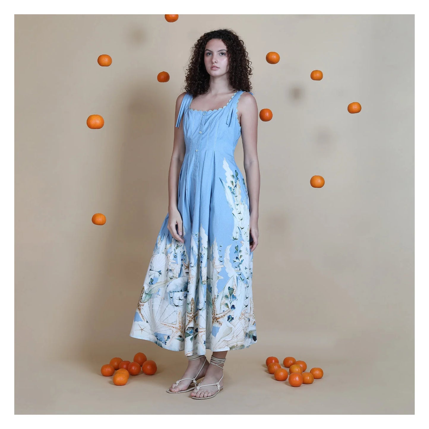 Blue cotton midi dress on model styled with sandals
