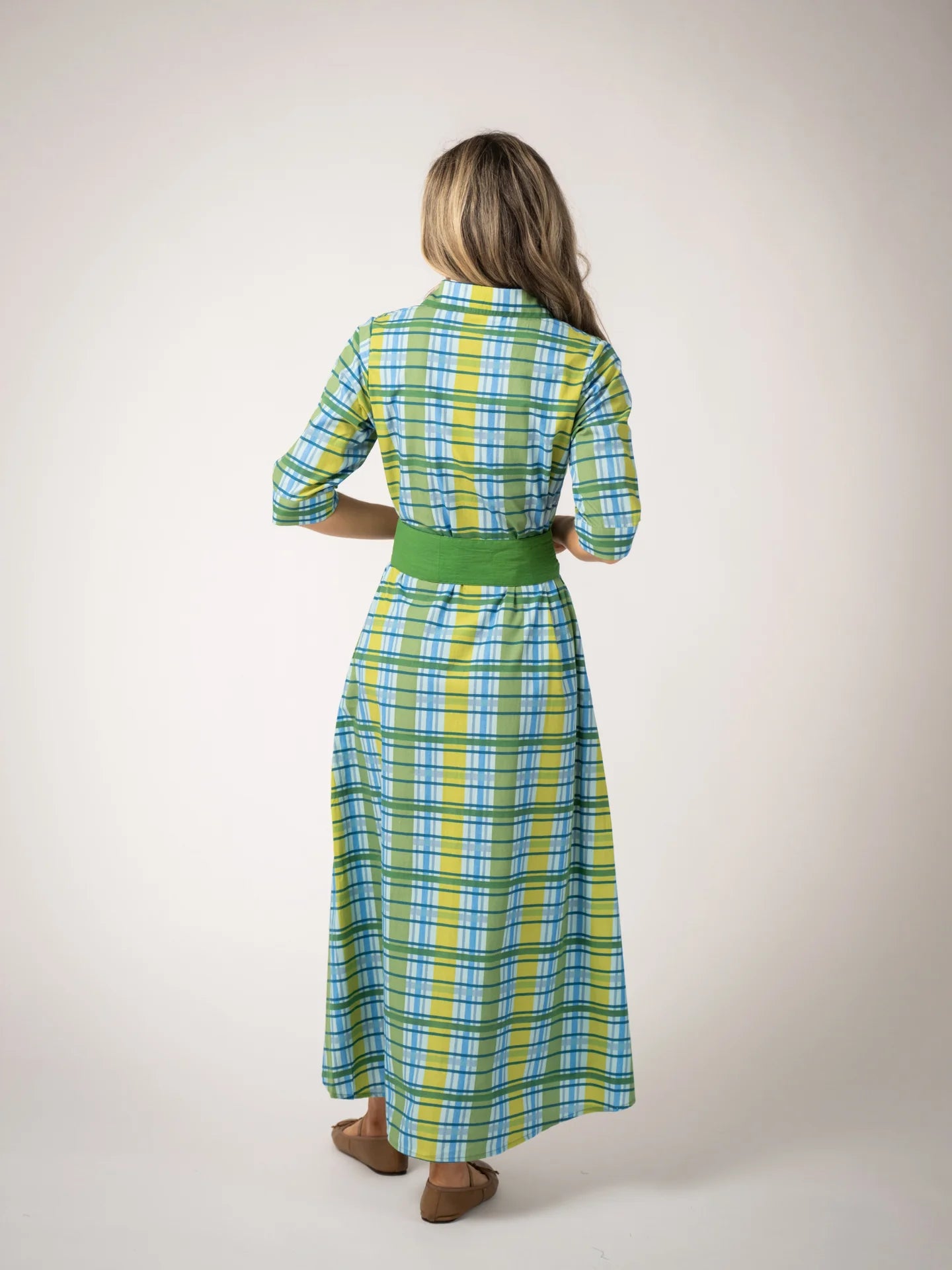 backview of model wearing green plaid maxi dress