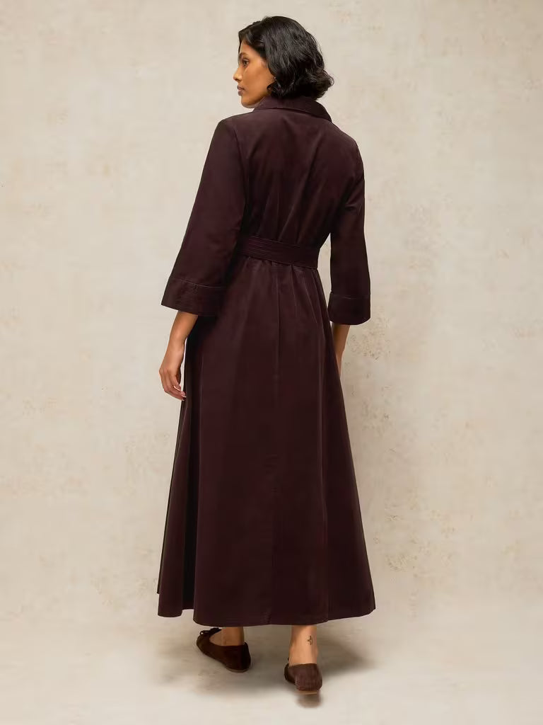 savvy | retail therapy back view of model wearing a corduroy shirtdress styled with a belt and ballet flats