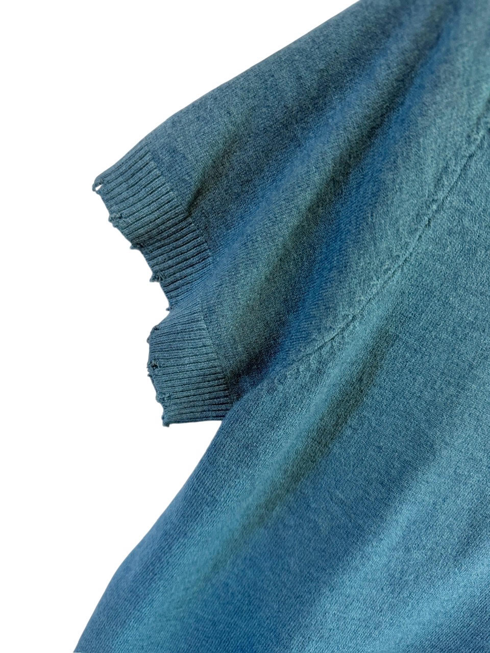 Savvy | retail therapy close up of a blue sweater sleeve with frayed edge detailing at the hem