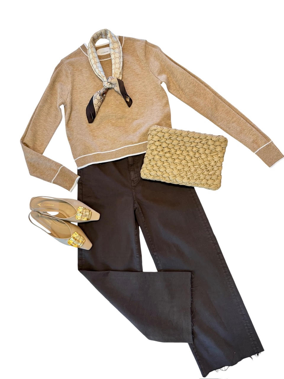 A styled flat-lay outfit on a white background featuring a beige knit sweater with a patterned neck scarf, dark charcoal pants, beige pointed-toe flats with gold detailing, and a textured beige clutch bag.