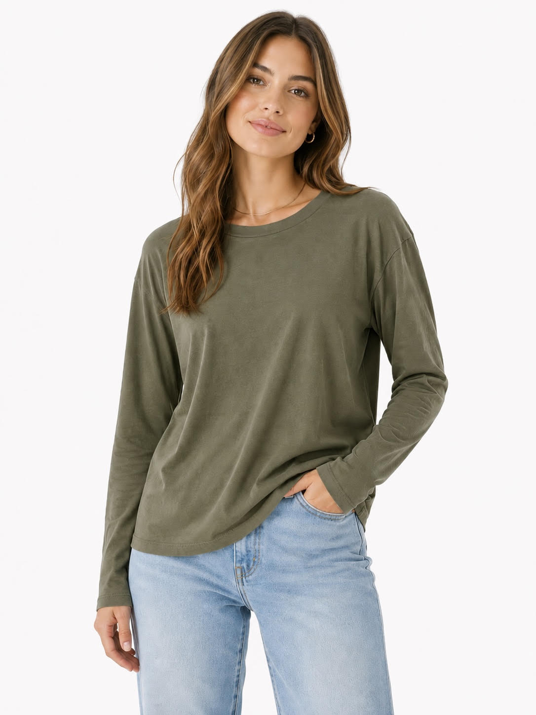 Savvy | retail therapy woman wearing a green long sleeve t-shirt styled with jeans against a white background