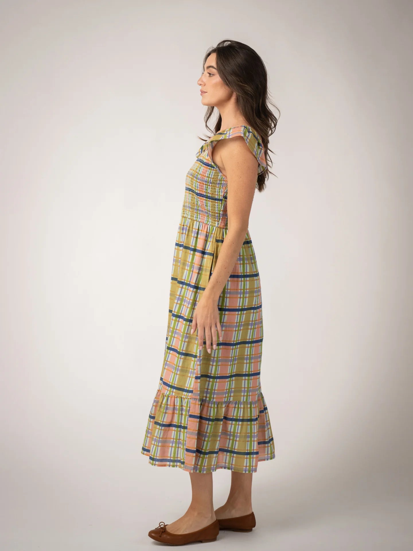 Woman wearing a plaid dress on a plain background